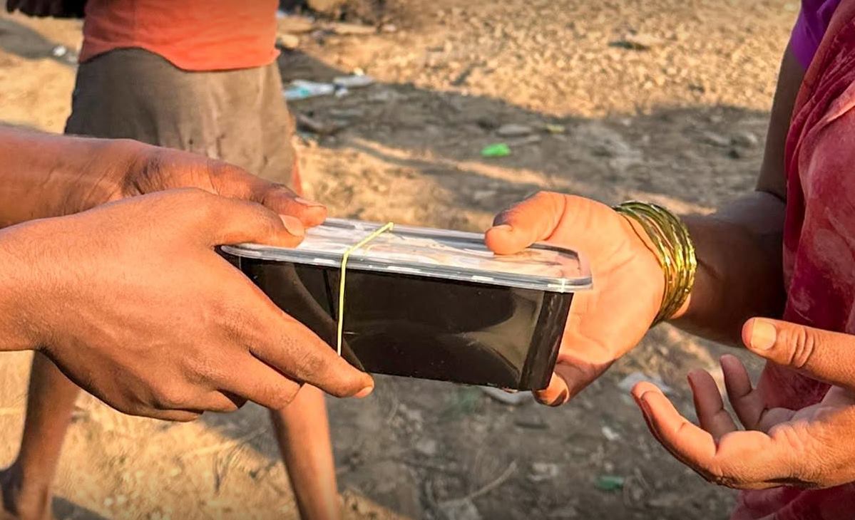 Handing a packed biryani box to a person Christmas 2025